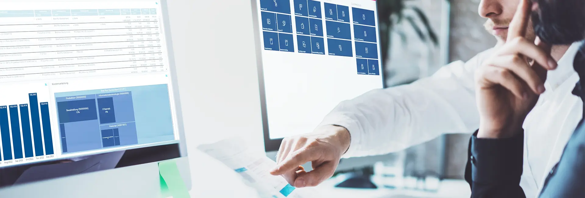 Zwei Personen analysieren Daten auf zwei Monitoren, einer zeigt Diagramme und Tabellen, während der andere eine Benutzeroberfläche mit Kacheln anzeigt.