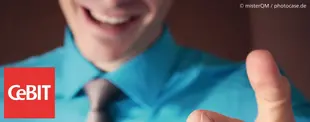 Das Bild zeigt einen lächelnden Mann in blauem Hemd und Krawatte, der in die Kamera zeigt, mit dem CeBIT-Logo in der unteren linken Ecke.