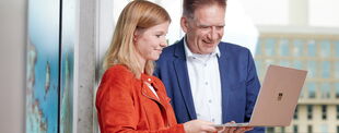 Das Foto zeigt Eva Branse und Uwe Rotermund während sie gemeinsam auf einen Laptop schauen.