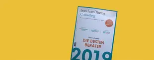 Das Magazin „brand eins Thema Consulting“ mit dem Titel „Die besten Berater 2019“ vor gelbem Hintergrund, schräg fotografiert.