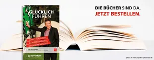 Das Bild zeigt ein aufgeschlagenes Buch und daneben ein Buchcover mit dem Titel „Glücklich Führen“. Daneben steht der Text „Die Bücher sind da. Jetzt bestellen.“