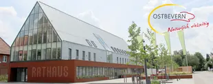 Foto vom Rathaus in Ostbevern und dem entsprechendem Logo.