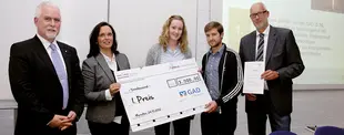 Fünf Personen stehen in einem Raum, zwei halten einen übergroßen Scheck für den 1. Preis des ERCIS Launch Pad 2012, gestiftet von der GAD.