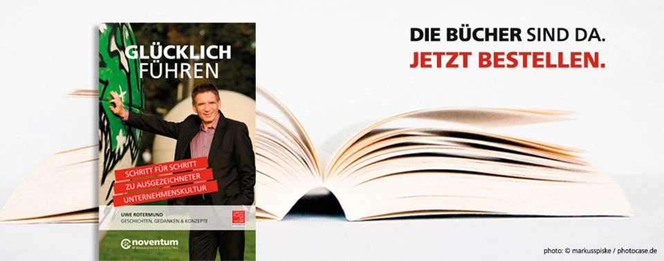 Das Bild zeigt ein aufgeschlagenes Buch und daneben ein Buchcover mit dem Titel „Glücklich Führen“. Daneben steht der Text „Die Bücher sind da. Jetzt bestellen.“